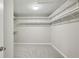 Empty walk-in closet with white shelves and neutral carpet at 4662 Creekside Villas Se Way, Smyrna, GA 30082