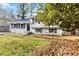 Split-level home with fresh paint, black shutters, and mature trees on a well-maintained lawn at 8331 Attica Ct, Jonesboro, GA 30238