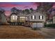 Exterior shot of a two-story home with a two-car garage and mature landscaping during dusk at 1117 Mountain Springs Nw Dr, Kennesaw, GA 30144