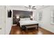 Main bedroom with a dark accent wall, bench at foot of the bed, and hardwood floors at 1524 Chateau Dr, Dunwoody, GA 30338