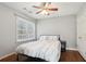 This bedroom features a ceiling fan, hardwood floors, and a bright window with natural light at 1524 Chateau Dr, Dunwoody, GA 30338