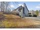 Back exterior view of the house showing deck, landscaping, retaining wall, and access to the lower level at 170 Maple View Ct, Dallas, GA 30157