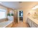 Well-lit bathroom features a shower, soaking tub, and double sink with a view into the bedroom at 1935 Azure Grove Ct, Marietta, GA 30008