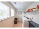 Functional laundry room with shelving, washer, dryer, and a window for ventilation and natural light at 1935 Azure Grove Ct, Marietta, GA 30008