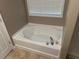 White bathtub with silver fixtures and window with blinds at 3999 Riverside Pkwy, Decatur, GA 30034