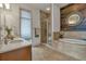 Bright bathroom features tiled floors, a walk-in shower, and a soaking tub with wood accent wall at 360 Chambers St # 301, Woodstock, GA 30188