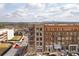 Brick building with shops on the ground floor, balconies on upper levels, and mountain views in the distance at 360 Chambers St # 301, Woodstock, GA 30188
