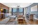 Open-concept living room with hardwood floors, modern furnishings, and large windows offering natural light and neighborhood views at 360 Chambers St # 301, Woodstock, GA 30188