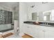 Modern bathroom with black countertop, double vanity, sleek tiling, and glass enclosed shower at 16 Ramsey St, Roswell, GA 30075