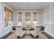 Elegant dining room with a rustic table, chandelier, and large windows with woven shades at 16 Ramsey St, Roswell, GA 30075