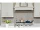 A beautifully appointed kitchen features stainless steel appliances and sleek, herringbone tile backsplash at 16 Ramsey St, Roswell, GA 30075