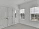 Bright bedroom featuring neutral carpet, and two windows with blinds at 225 Sims Park Pl, Suwanee, GA 30024