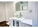 Bright bathroom features a modern glass bowl sink, white vanity, and gray wood-look flooring at 4180 Mount Paran Dr, Social Circle, GA 30025