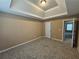 Spacious carpeted bedroom features tray ceiling and doorway to another room at 4667 Derby Loop, Fairburn, GA 30213