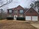Charming brick two-story home featuring an attached two-car garage and manicured landscaping at 4667 Derby Loop, Fairburn, GA 30213