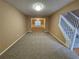 Comfortable living area featuring neutral carpet and an open layout with ample natural light at 4667 Derby Loop, Fairburn, GA 30213