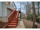 Exterior stairs lead to the homes upper level, showcasing backyard and wooded surroundings at 10440 Cranchester Way, Alpharetta, GA 30022