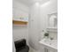 Bathroom featuring modern sink, vanity and round mirror with hanging shelves and black toilet at 10440 Cranchester Way, Alpharetta, GA 30022