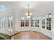 Sun-drenched breakfast nook with a bay window and decorative chandelier at 10440 Cranchester Way, Alpharetta, GA 30022