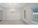 Formal dining room with decorative chandelier, chair rail, and crown molding at 10440 Cranchester Way, Alpharetta, GA 30022