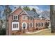 Beautiful brick home with a well-manicured lawn, black shutters, and lush landscaping at 10440 Cranchester Way, Alpharetta, GA 30022