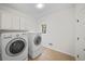 Convenient laundry room with washer, dryer, and overhead cabinets at 10440 Cranchester Way, Alpharetta, GA 30022