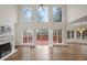 Open living room showcasing hardwood floors, a fireplace, and double doors leading to the outdoor deck at 10440 Cranchester Way, Alpharetta, GA 30022