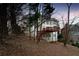 The rear exterior of the house features a deck with stairs to the ground level and views of a wooded backyard at 10440 Cranchester Way, Alpharetta, GA 30022