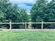 Backyard view showcasing a wood fence bordering the lawn and trees in the distance at 3428 Stembler Rdg, Douglasville, GA 30135