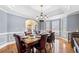 Formal dining room featuring hardwood floors, wainscoting, crown molding, and a stylish chandelier at 3428 Stembler Rdg, Douglasville, GA 30135