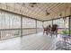 Inviting covered back porch with ceiling fans, outdoor dining furniture, and wooded views at 1050 Silver Thorne Dr, Loganville, GA 30052