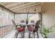 Cozy covered back porch area with wooded views, ceiling fan, and outdoor dining table at 1050 Silver Thorne Dr, Loganville, GA 30052