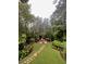 Secluded backyard showcasing mature trees, lush grass, firepit, and stone pathway at 1050 Silver Thorne Dr, Loganville, GA 30052