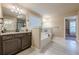 Bright bathroom showcasing a soaking tub, double vanity, and walk in closet access at 1050 Silver Thorne Dr, Loganville, GA 30052