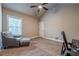Neutral bedroom featuring carpet flooring, ceiling fan, and a patterned chair with ottoman at 1050 Silver Thorne Dr, Loganville, GA 30052