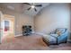 Neutral bedroom featuring carpet flooring, ceiling fan, and a patterned chair with ottoman at 1050 Silver Thorne Dr, Loganville, GA 30052