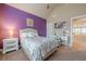 This bedroom features a vivid purple accent wall, a comfortable bed, and a stylish white vanity at 1050 Silver Thorne Dr, Loganville, GA 30052
