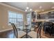 Dining area with a glass table, seating for four, and natural light from the large window at 1050 Silver Thorne Dr, Loganville, GA 30052