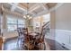 Spacious dining room showcasing hardwood floors, coffered ceiling, and backyard window at 1050 Silver Thorne Dr, Loganville, GA 30052