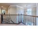 Hallway with carpet, wooden railing, and views of the stairwell at 1050 Silver Thorne Dr, Loganville, GA 30052