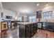 Open concept kitchen with black cabinets and hardwood floors with island open to the living room at 1050 Silver Thorne Dr, Loganville, GA 30052