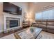 Cozy living room with a stone fireplace and comfortable seating, filled with natural light at 1050 Silver Thorne Dr, Loganville, GA 30052