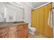 A well-lit bathroom featuring a single sink vanity, a toilet and a shower with a curtain at 2373 Greenglade Ne Rd, Atlanta, GA 30345