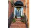 Elegant front entry with a decorative glass door, black awning, potted plants, and brick steps at 1210 Thistle Gate Path, Lawrenceville, GA 30045