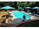 Refreshing pool with blue umbrellas and lounge chairs provides a relaxing outdoor oasis at 1210 Thistle Gate Path, Lawrenceville, GA 30045