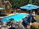 Sparkling in-ground pool with poolside seating and umbrellas in a well-maintained backyard at 1210 Thistle Gate Path, Lawrenceville, GA 30045