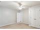 Neutral bedroom with a ceiling fan, closet with bi-fold doors, and an open door leading to another room at 3641 Willow Club Dr, Loganville, GA 30052