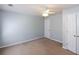 Neutral bedroom featuring a ceiling fan, tan carpet, and white doors at 3641 Willow Club Dr, Loganville, GA 30052