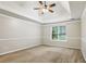 Carpeted bedroom features tray ceilings, ceiling fan, and a large window at 3641 Willow Club Dr, Loganville, GA 30052