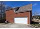 Two-car garage of brick home with neutral door in a residential area with driveway and partial landscaping at 3641 Willow Club Dr, Loganville, GA 30052